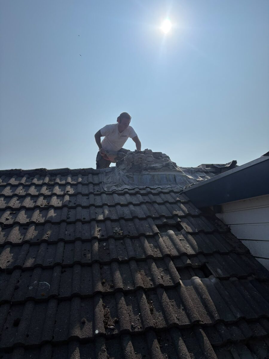 Vakman van De Birrus Metselwerken breekt de schoorsteenpot veilig af op hoogte