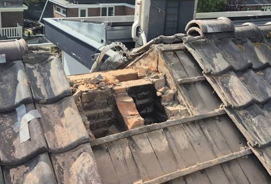 Schoorsteen afgebroken tot op het dakvlak, met zicht op de ontstane opening